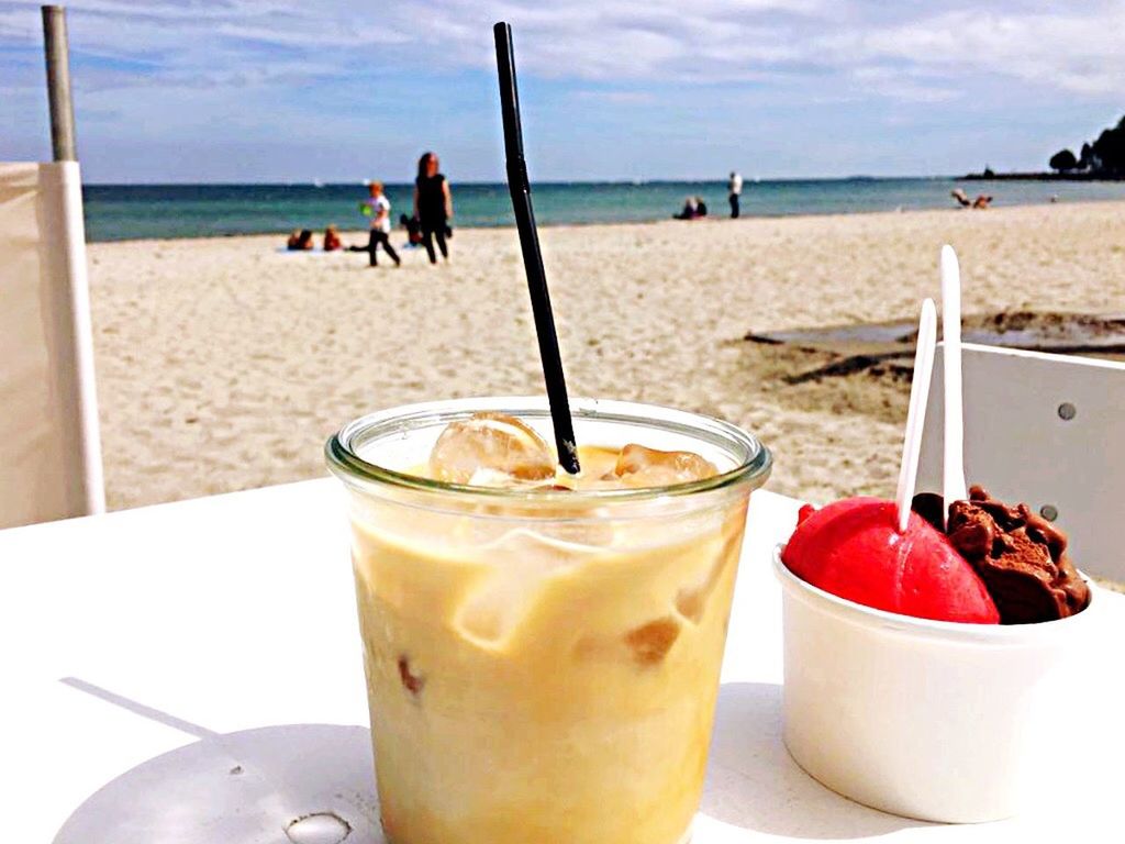 CLOSE-UP OF DRINK ON BEACH