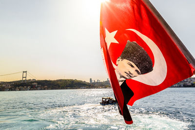 Red umbrella on boat at sea against sky