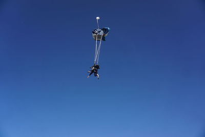 Low angle view of man sky diving against sea