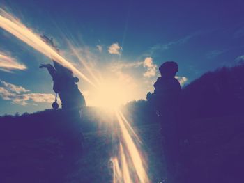 Silhouette men against sky during sunset