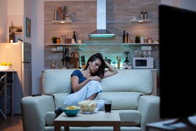 Portrait of woman sitting on sofa at home