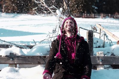 Cheerful mid adult man playing with snow