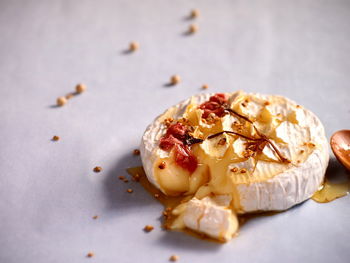 Baked camembert cheese with agave syrup and pickled cherry blossoms on top