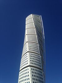 Low angle view of skyscrapers against blue sky