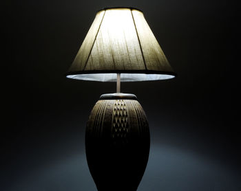 Close-up of illuminated lamp against black background