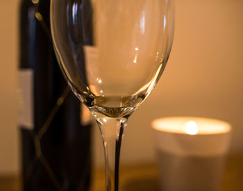 Close-up of empty wineglass by lit candle