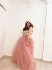 Low angle view of young woman standing against wall