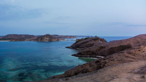 Scenic view of sea and mountains against sky