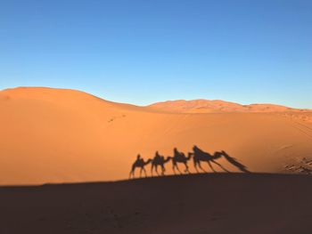 Scenic view of desert against clear blue sky