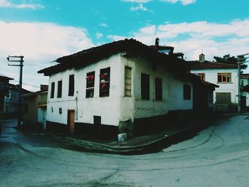 Houses by street against sky in city