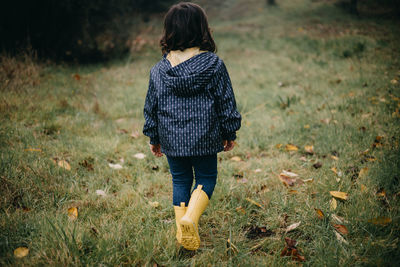 Rear view child walking on the grass