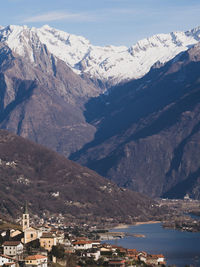 Aerial view of townscape by mountain against sky