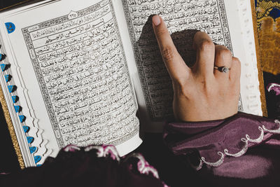 High angle view of human hand on book