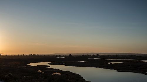 Scenic view of river against sky during sunset