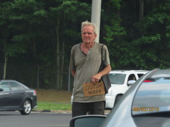 Portrait of man standing in car