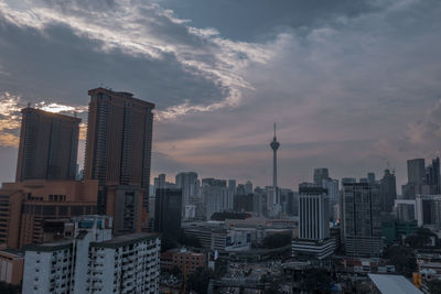 Modern buildings in city against cloudy sky