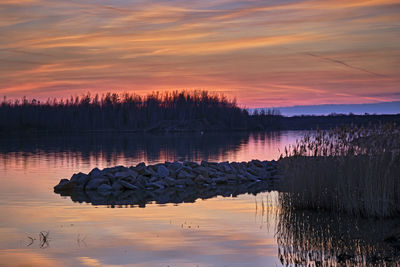 Scenic view of lake against orange sky