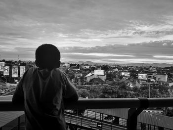 Rear view of boy looking at city from observation tower