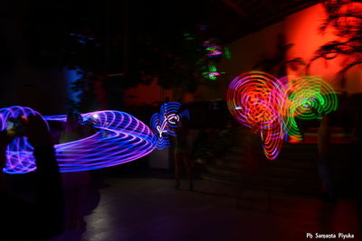 Blurred motion of illuminated ferris wheel at night