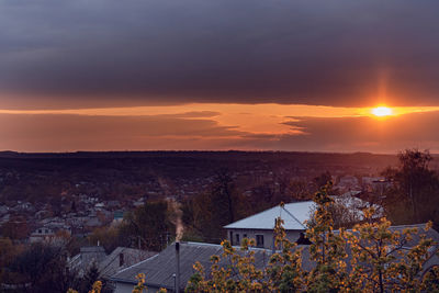 High angle view of trees and buildings against sky during sunset