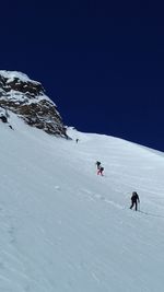 People on snowcapped mountain against sky