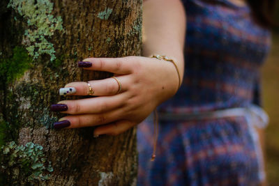 Close-up of young woman standing by tree