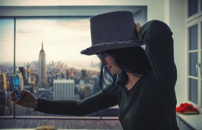 Woman photographing through smart phone in city