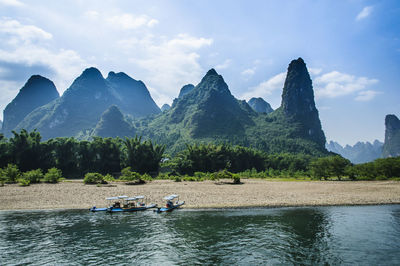 Scenic view of river and mountains against sky