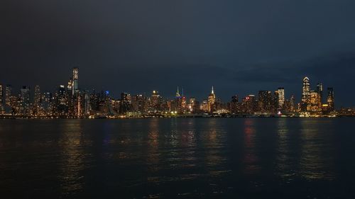 Illuminated buildings in city against sky at night