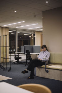 Young businesswoman using laptop while working late at work place