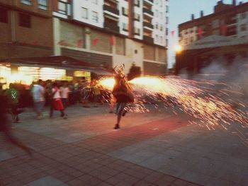 Woman standing on illuminated city street at night