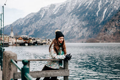 Woman smiling against lake and mountains