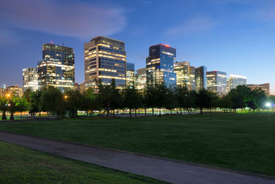 Illuminated buildings in city against sky