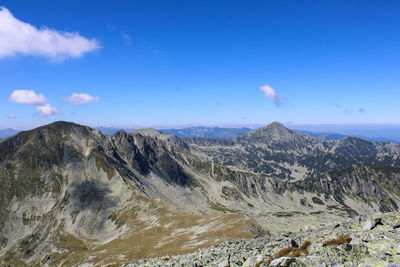 Scenic view of mountains against blue sky