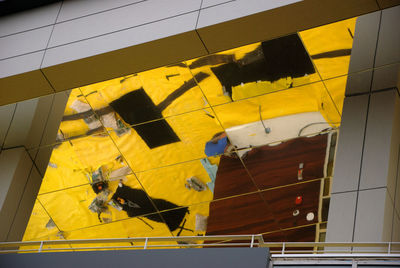 Man working against yellow building