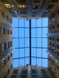 Low angle view of modern buildings against blue sky