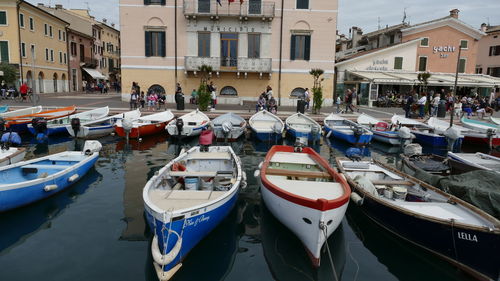 Boats moored in canal amidst buildings in city