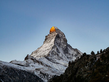 Low angle view of snowcapped mountain against clear sky