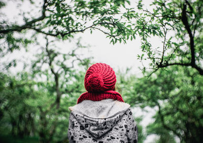 Rear view of woman wearing warm clothing at forest