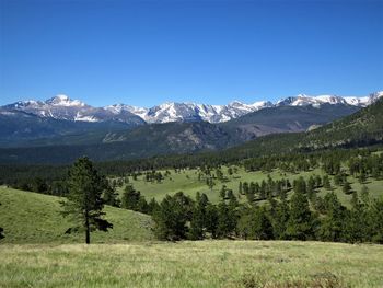 Scenic view of field and mountains against clear sky