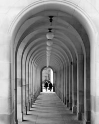 Rear view of people walking in corridor of building