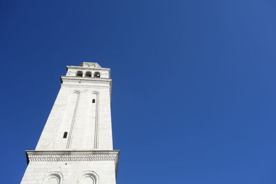 Low angle view of clock tower against blue sky