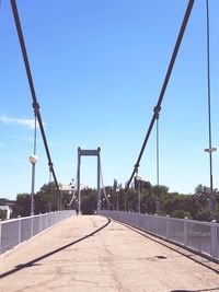 Empty bridge against clear blue sky