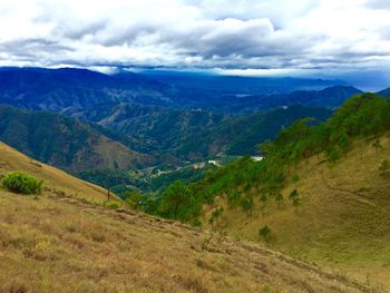 Scenic view of mountains against cloudy sky