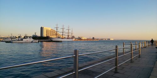 Scenic view of sea and buildings against clear sky