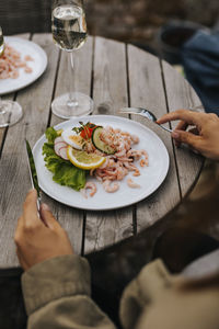 Person eating prawn sandwich outdoors