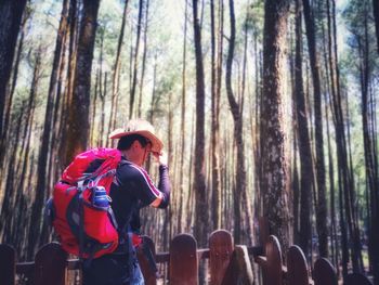 Rear view of people photographing in forest