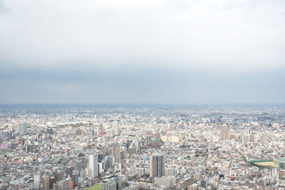 High angle view of city by sea against sky