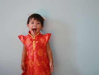 Portrait of girl standing against wall