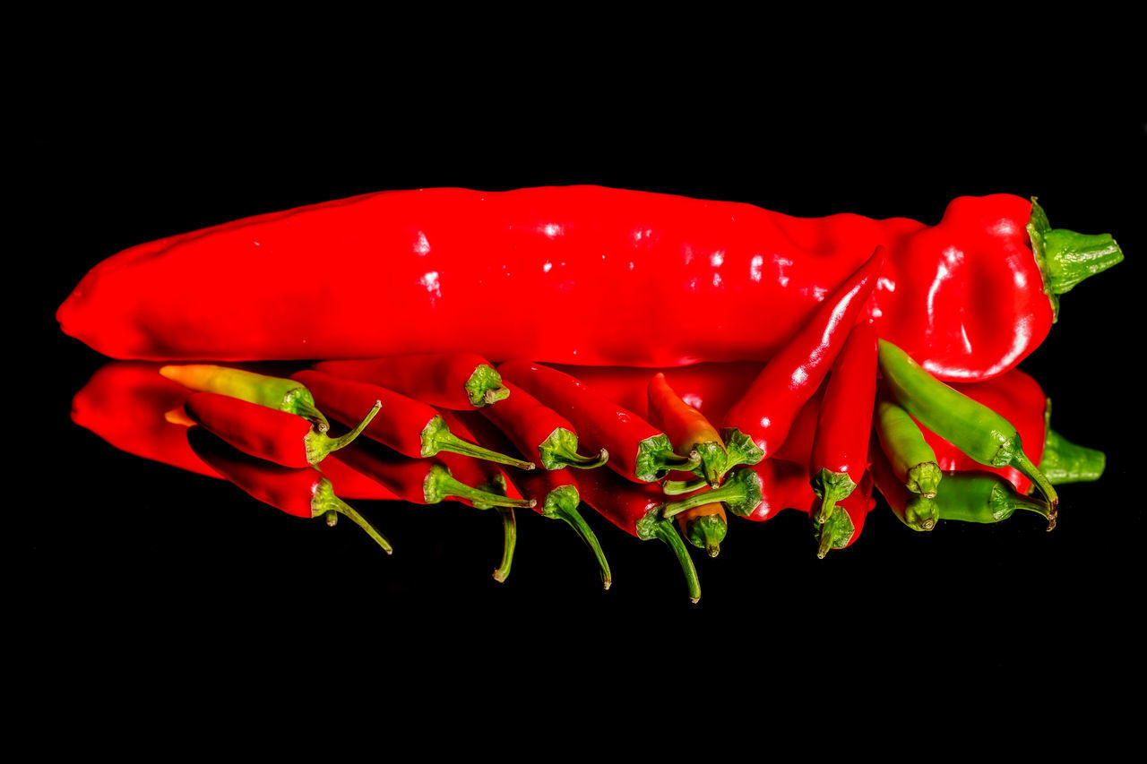 CLOSE-UP OF RED CHILI PEPPERS IN BLACK BACKGROUND